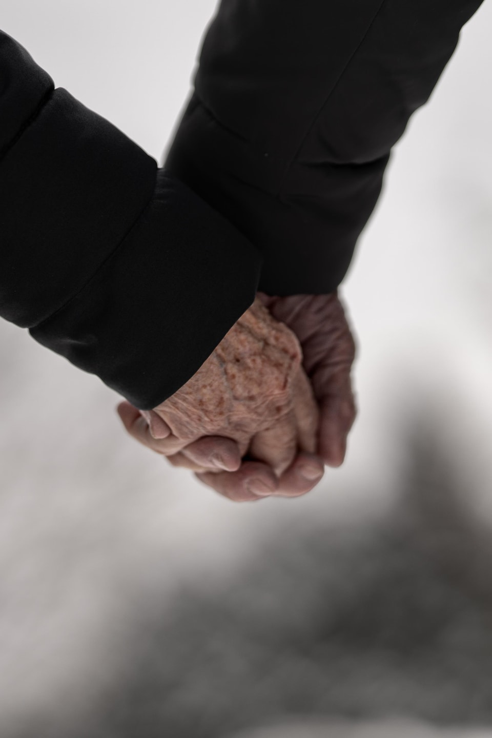 Des mains d'aînés enlacées.