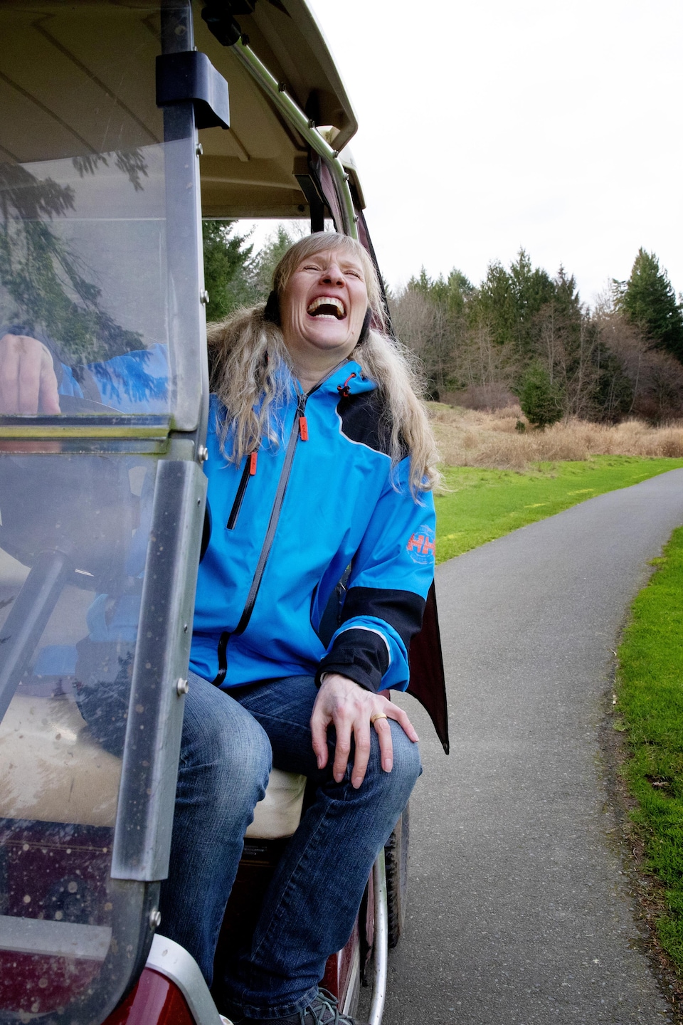 Une femme dans une voiturette de golf.