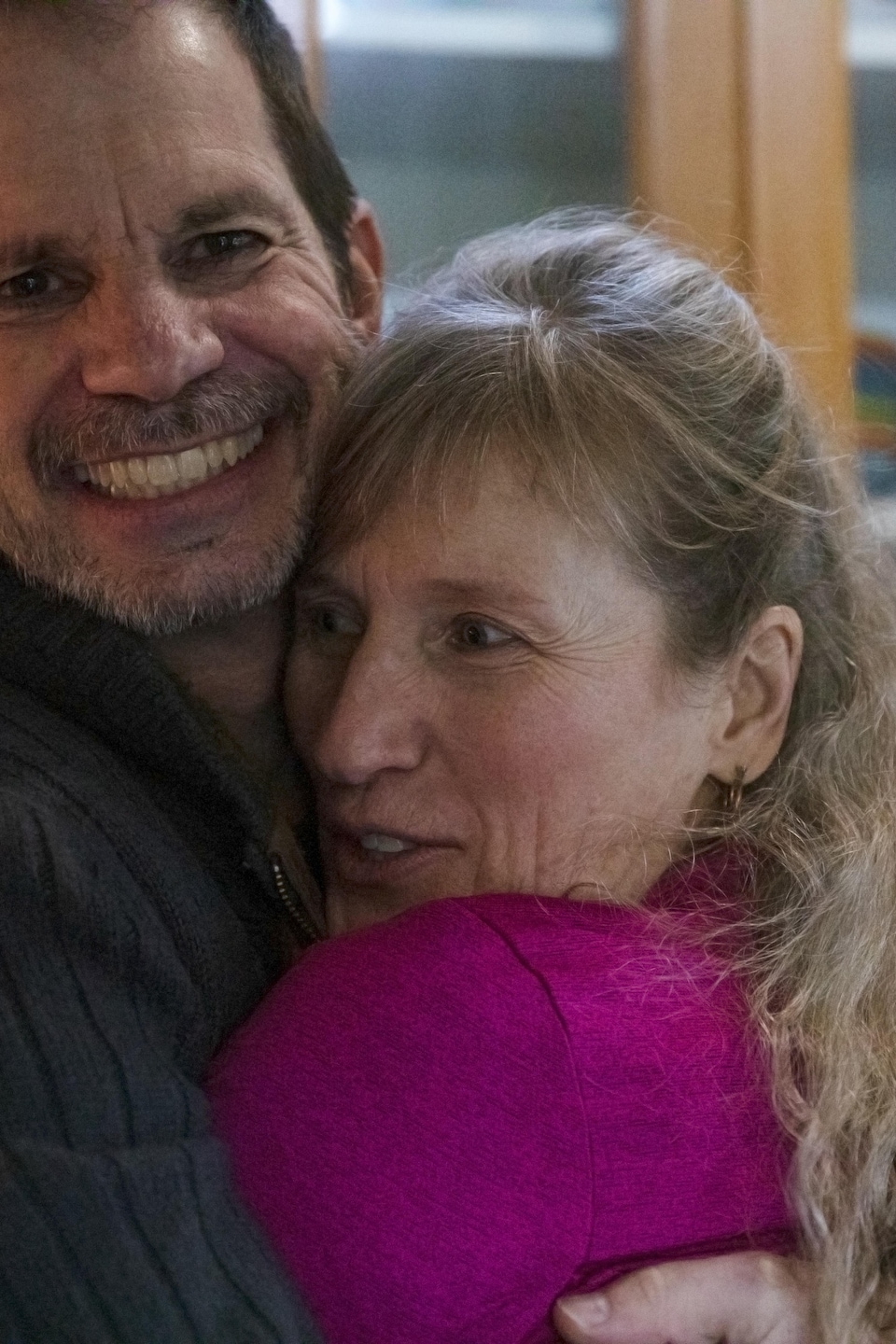 Un homme et une femme se reconfortent en se serrant dans leurs bras.