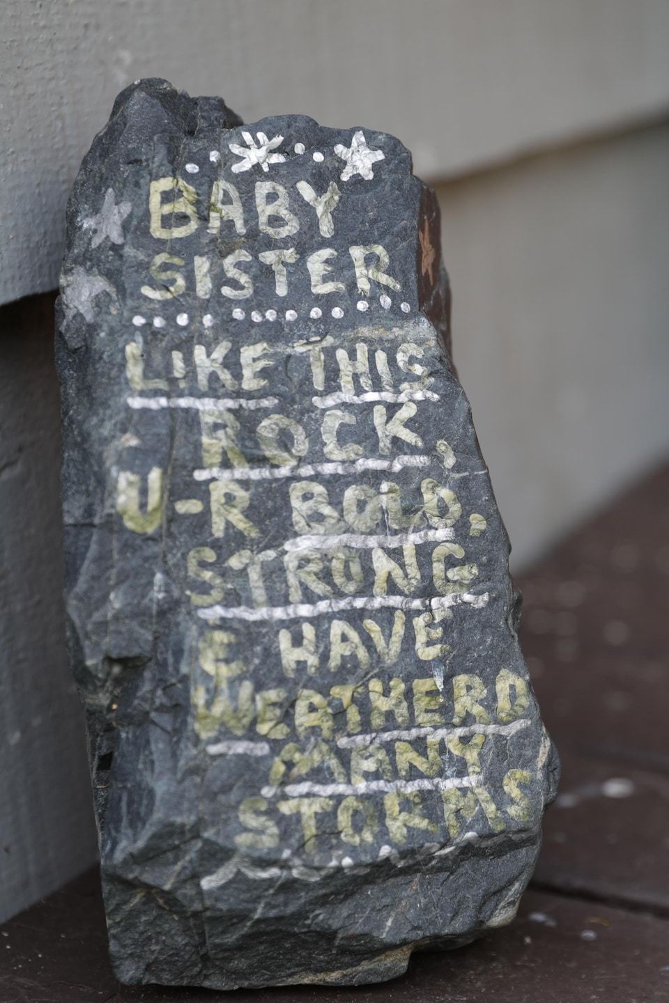 Le message écrit est : Baby sister, like this rock, u-r bold, strong & have weathered many storms. 