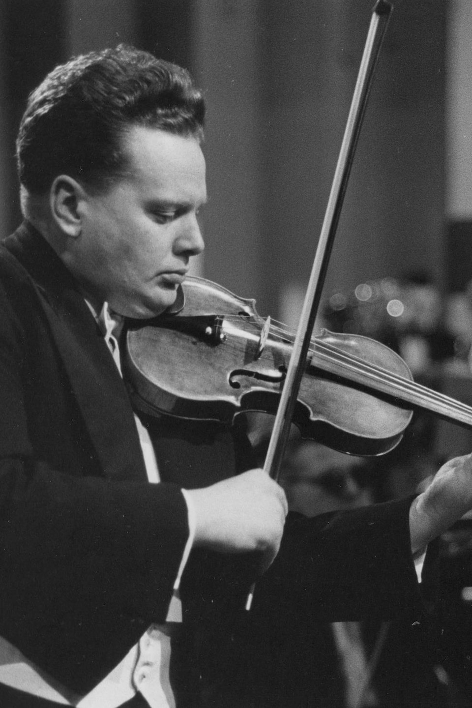 Arthur Davidson jouant du violon devant un orchestre.