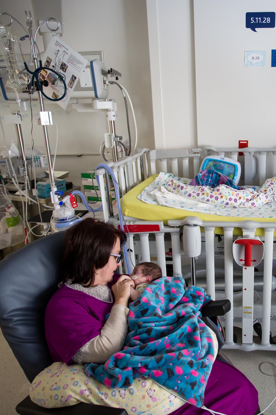 Louise Lafond tient un bébé dont le pouls est surveillé par de l'équipement médical.