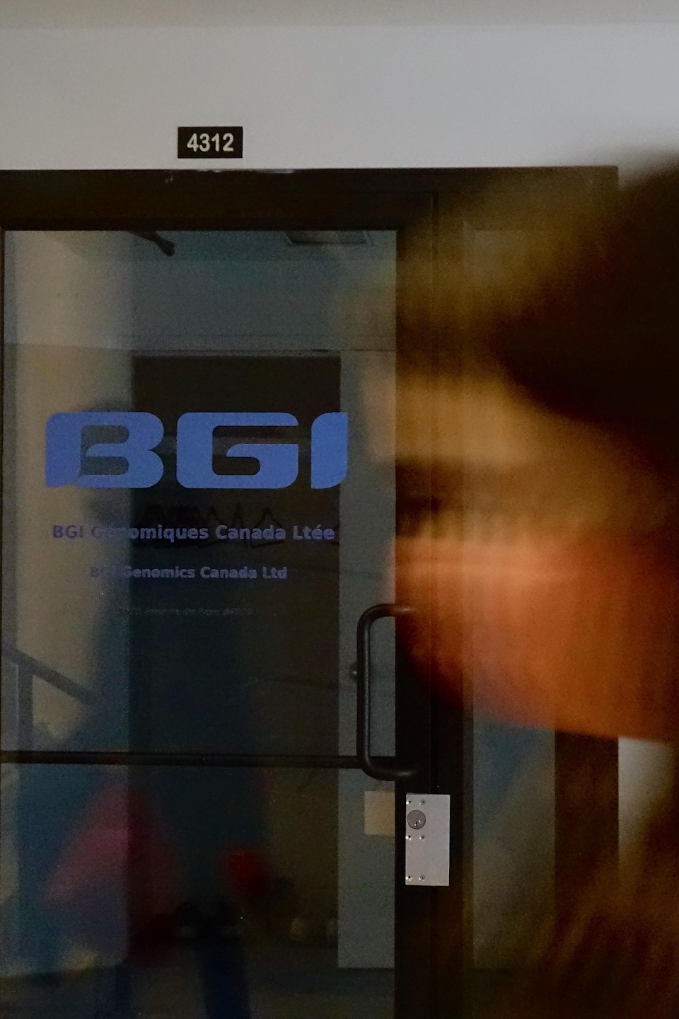 Deux personnes passent devant les locaux de BGI sur l’avenue du Parc, à Montréal.

