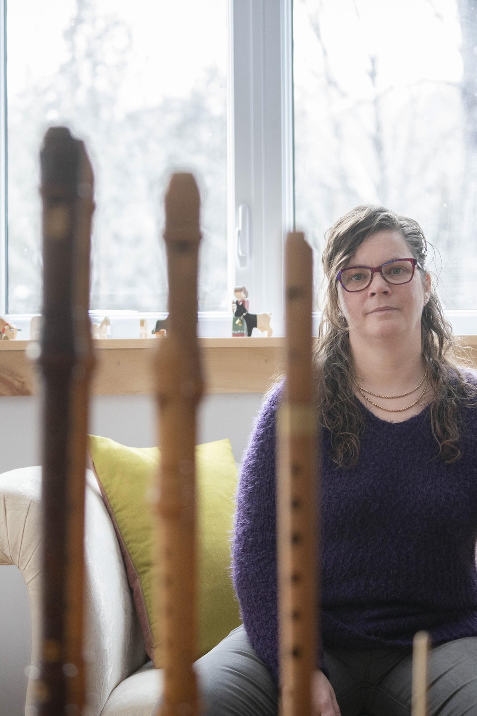 Cécilia Lauenstein avec sa canne dans son salon devant ses flûtes.