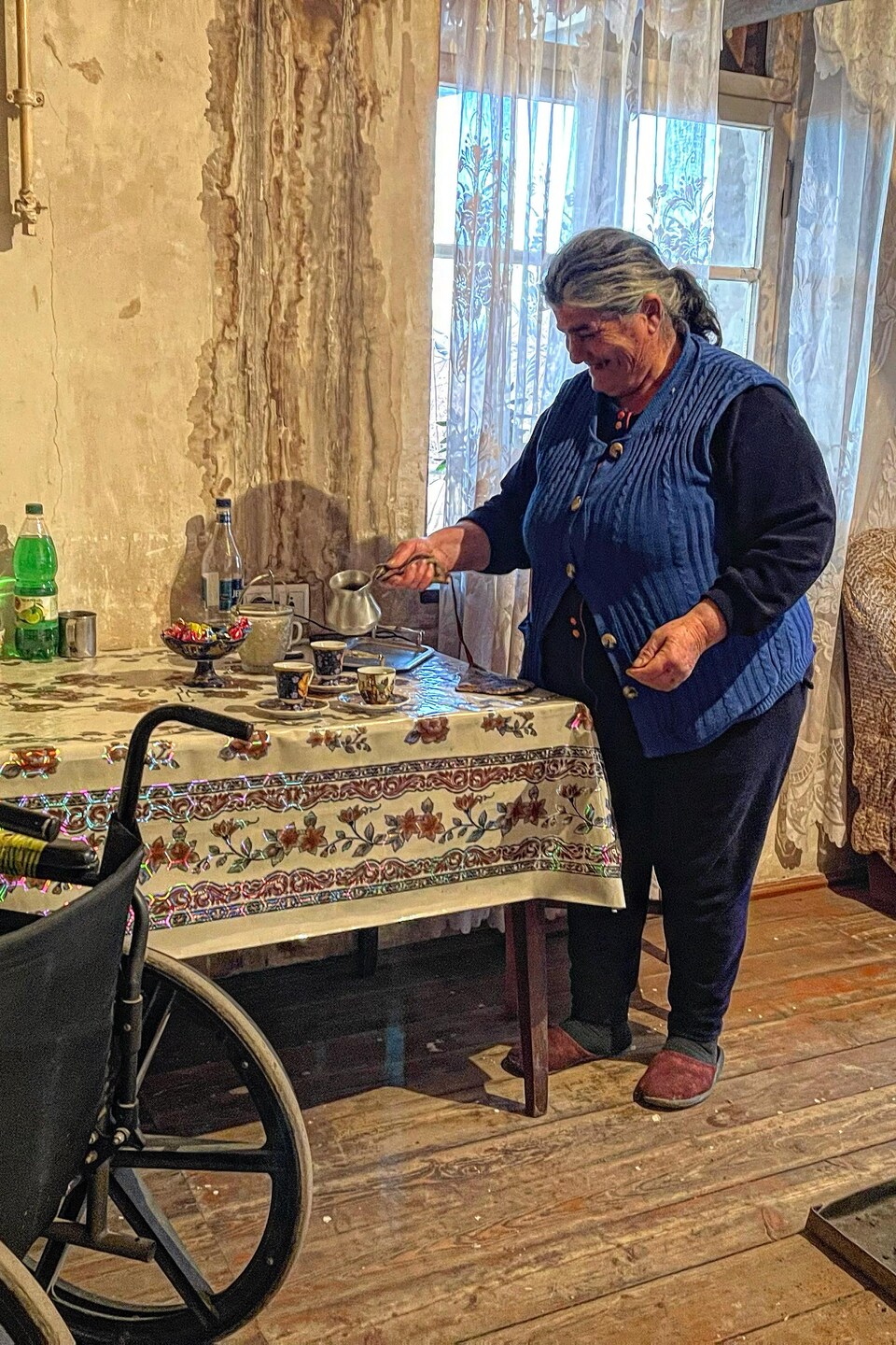 Une femme sert le café dans des tasses sur une table.