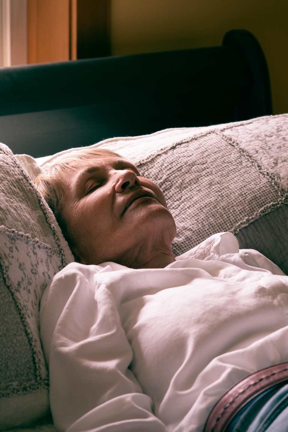 Mona Strelaeff, allongée sur le dos, les yeux fermés, sur son lit.