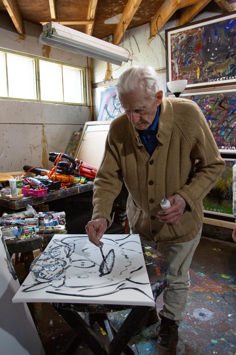 Clément Gravel débute une toile dans son atelier.