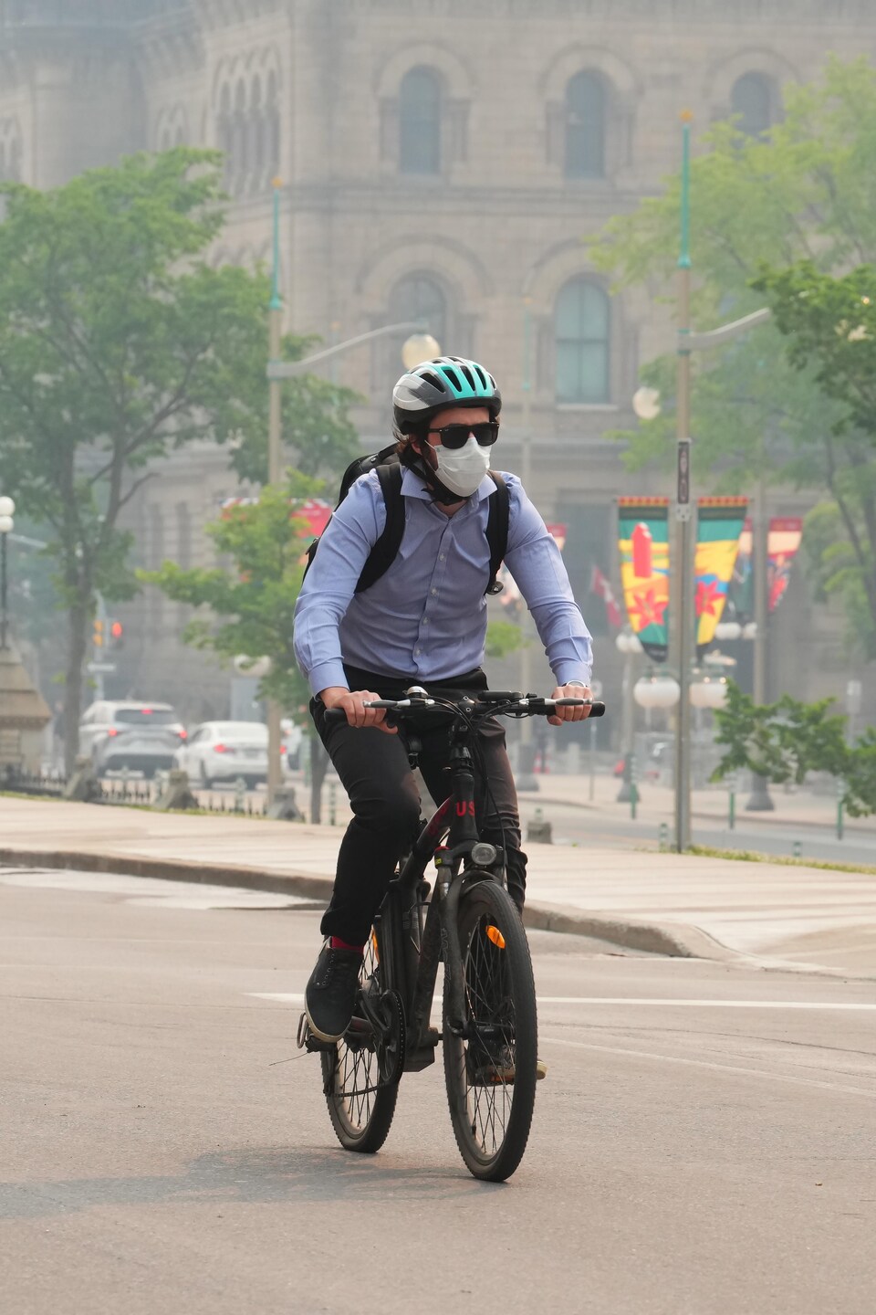 Un cycliste porte un masque dans une rue d'Ottawa.