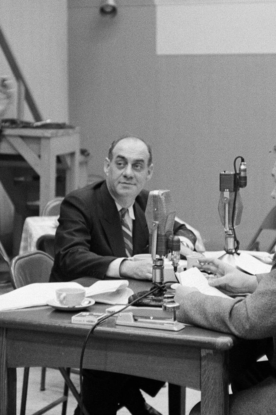 Dans un studio de radio, une femme non identifiée, le réalisateur Paul Legendre
qui tape des mains, l'animateur Miville Couture, Jean Mathieu et Lorenzo Campagna, assis à la table.
