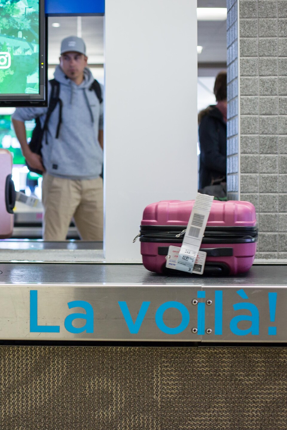 Un convoyaeur à bagage avec l'inscription «La voilà»