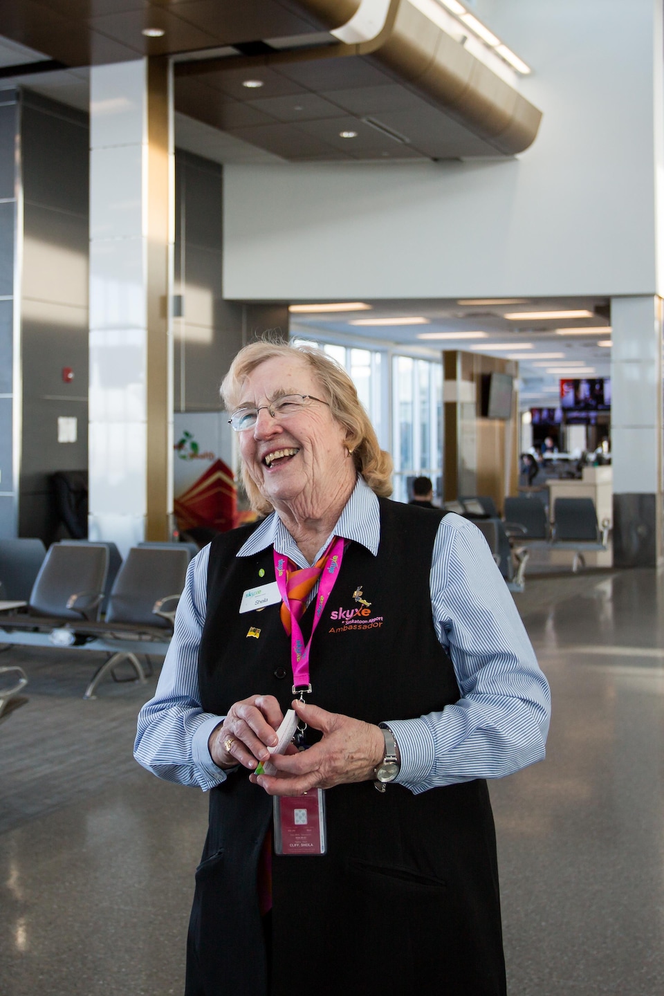 Une employée de l'aéroport qui discute avec un voyageur