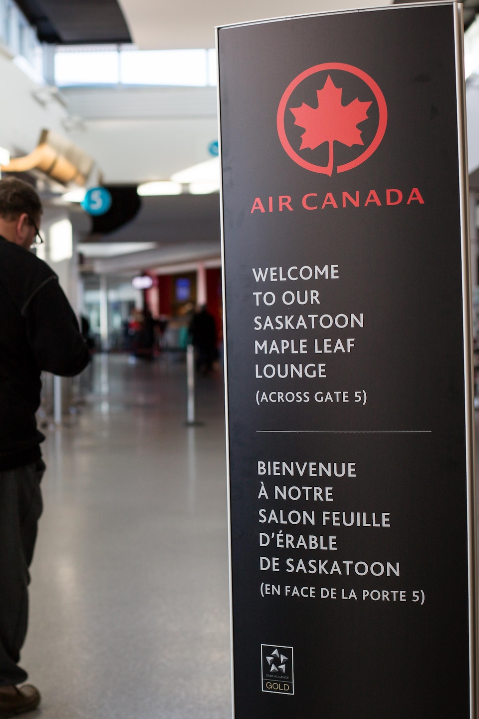 Une affiche de la compagnie aérienne Air Canada qui souhaite la bienvenue au salon feuille d'érable dans les deux langues