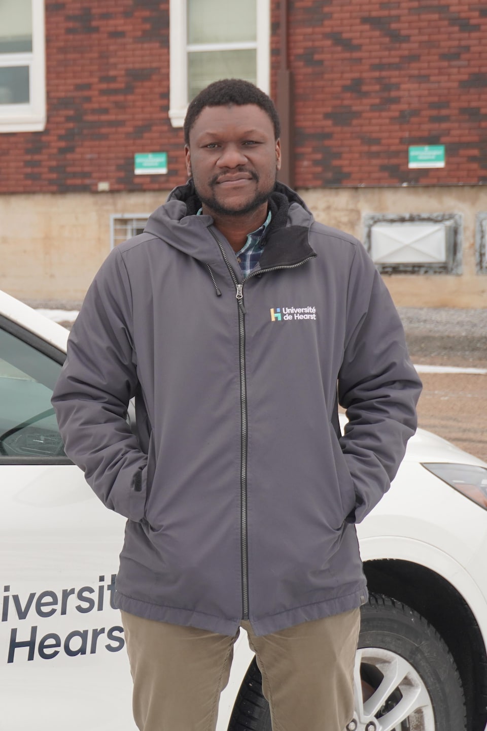 Papa Ibrahima Coulibaly près d'une voiture de l'Université de Hearst.