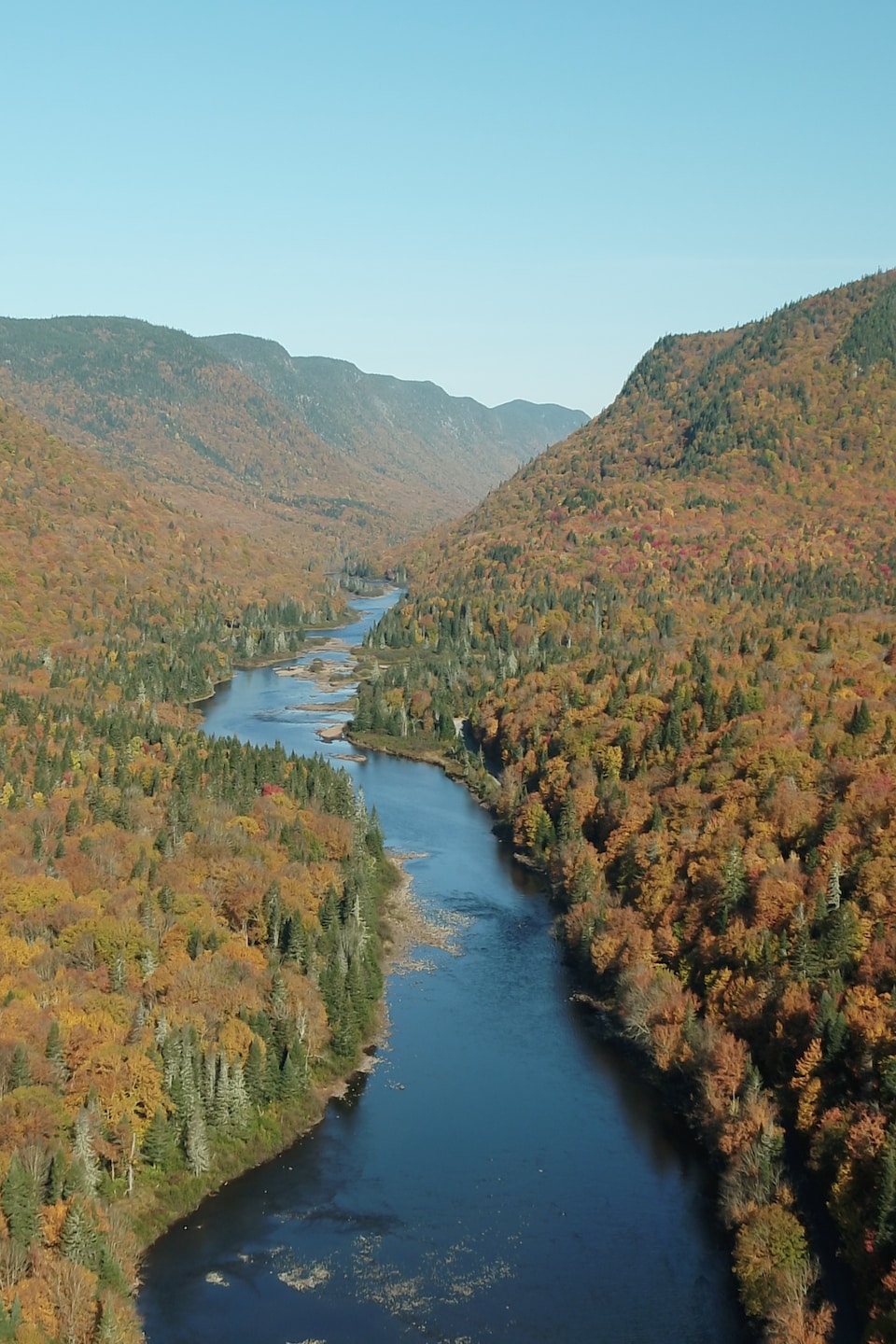 Capture d'écran d'une vidéo filmée par drone aérien au-dessus de la rivière. On aperçoit la vallée montagneuse au loin.