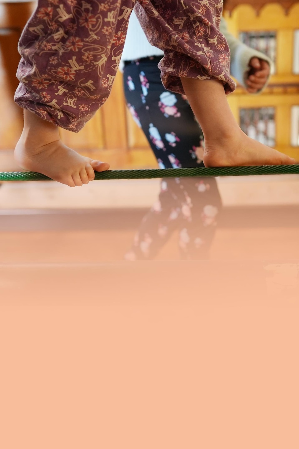 Gros plan sur les pieds d'une jeune fille en équilibre sur une corde.