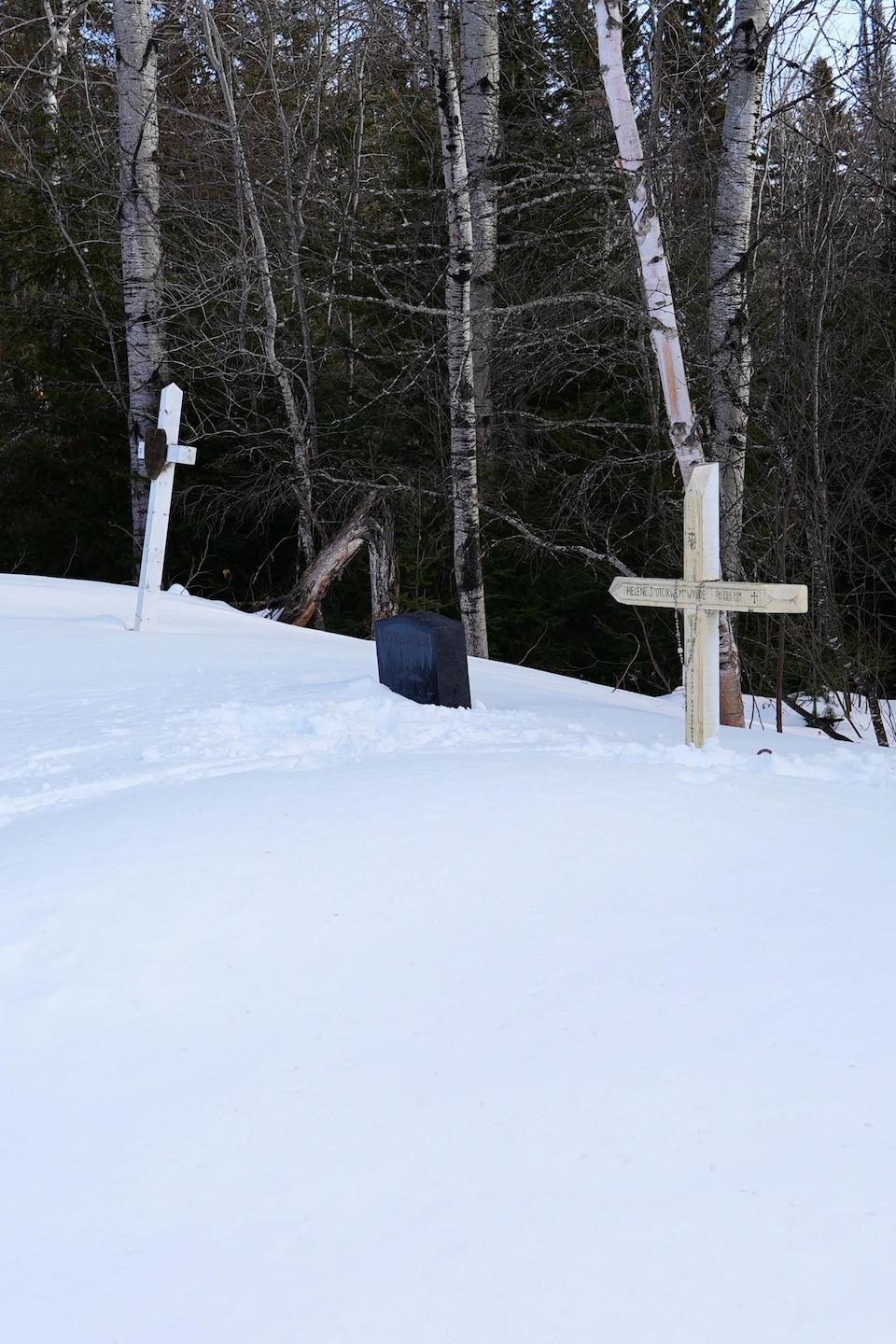 La neige cache une partie des croix au cimetière de Pikogan.