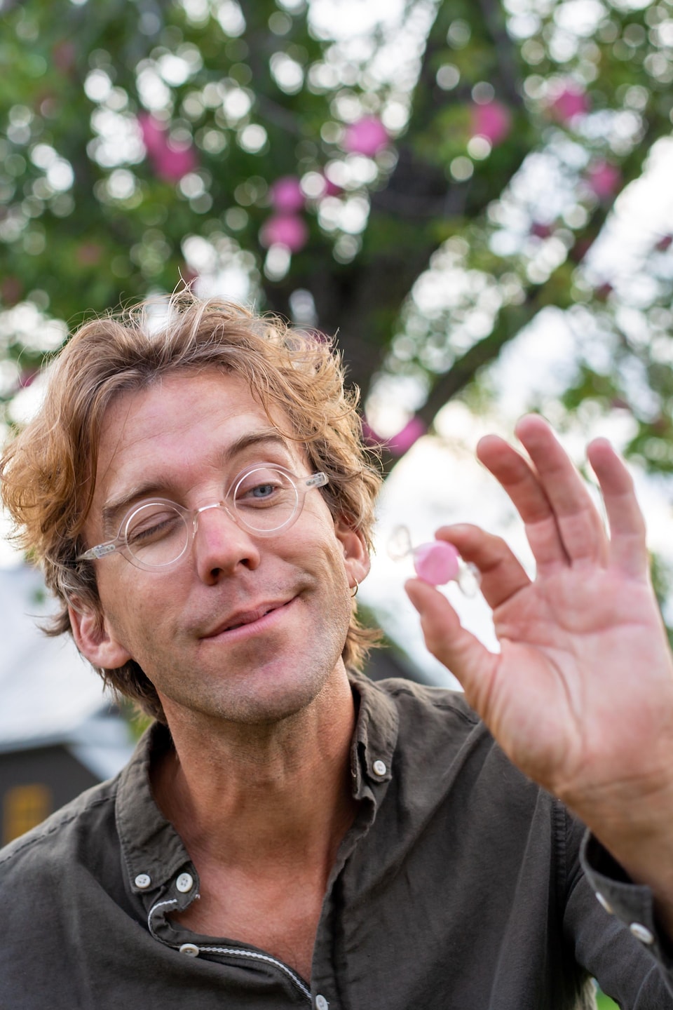 Fred Pellerin tient un bonbon rose entre ses doigts.