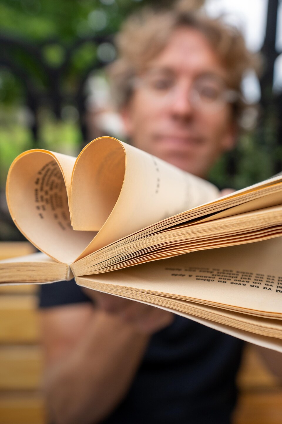 Fred Pellerin tient un livre avec des pages qui forment un coeur.