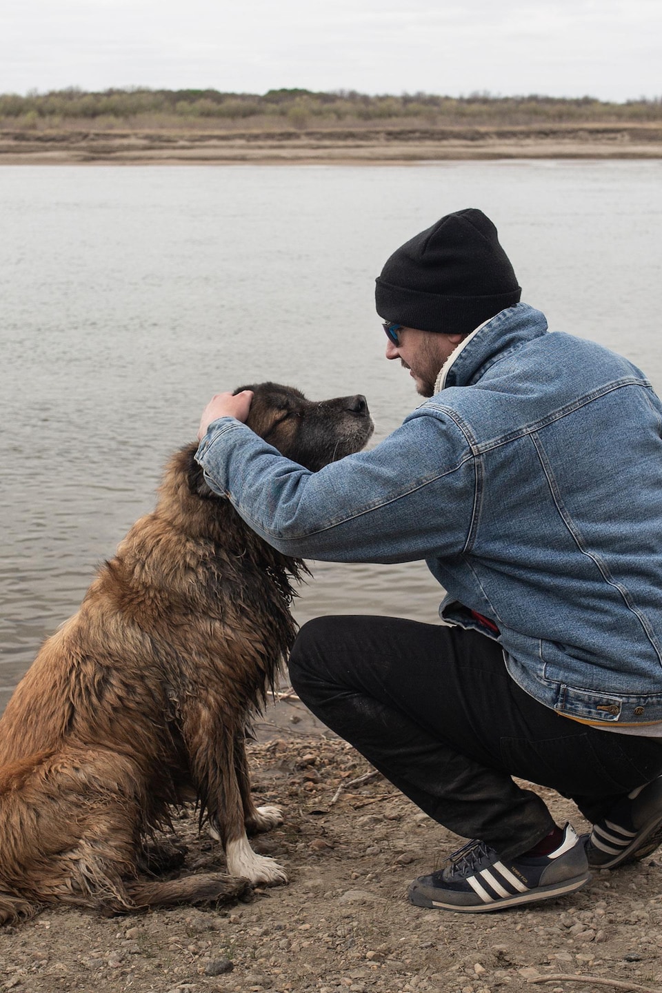Jason Mercredi et sa chienne Pinch au bord d'un plan d'eau.