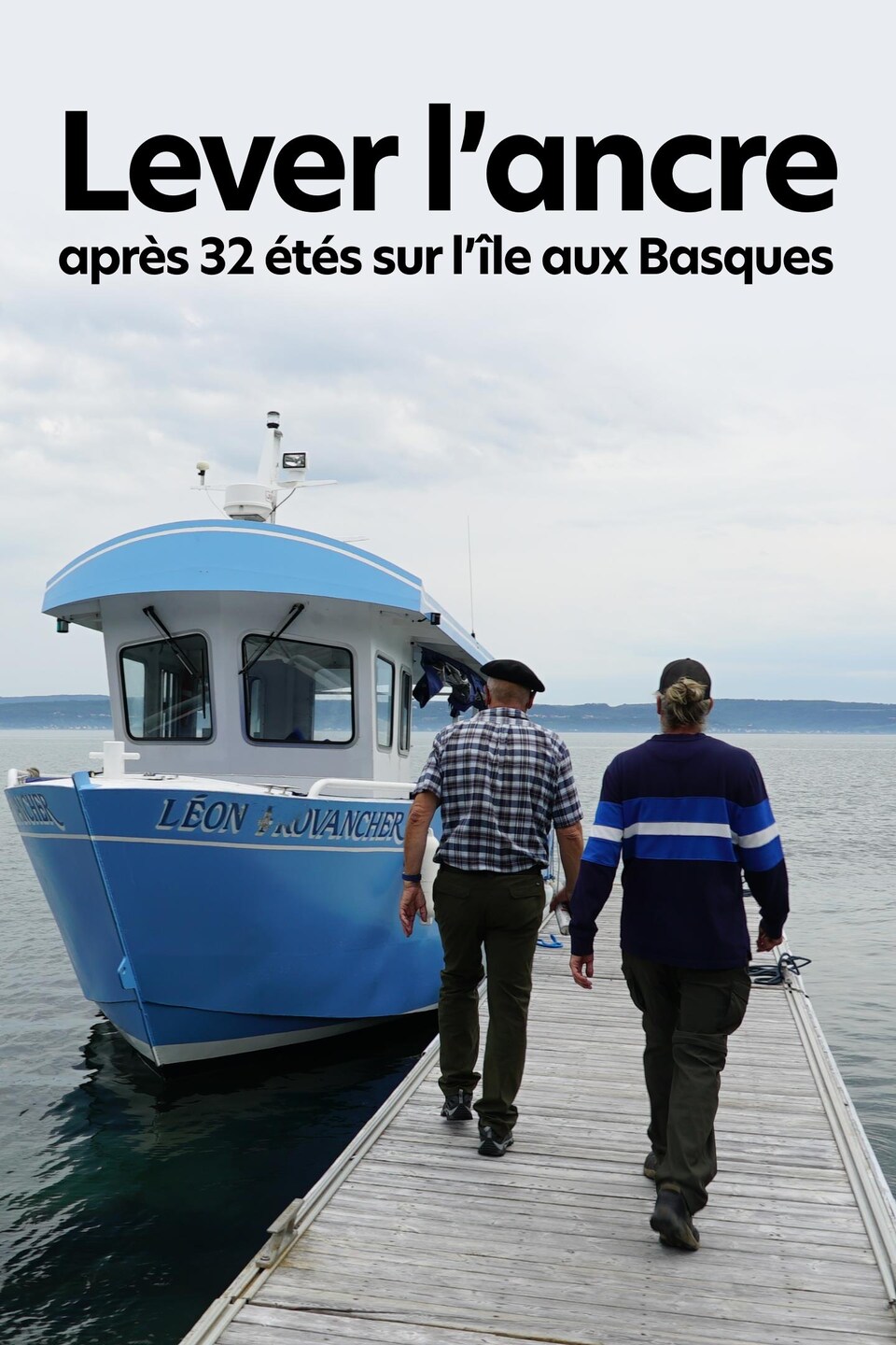 Jean-Pierre Rioux et Mikael Rioux se dirigent vers un bateau amarré au quai.