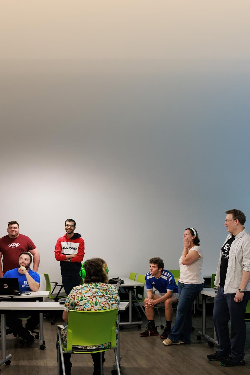 Un groupe de personne discute en regardant un écran où une version préliminaire d'un jeu est projetée.