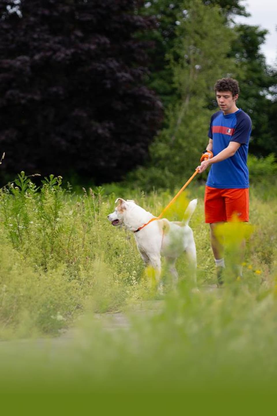 Louis qui tient son chien en laisse.