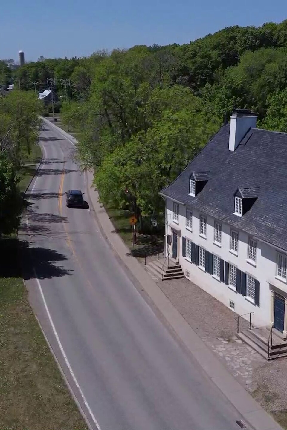 Une auto qui passe à côté d'une bâtiment patrimonial.