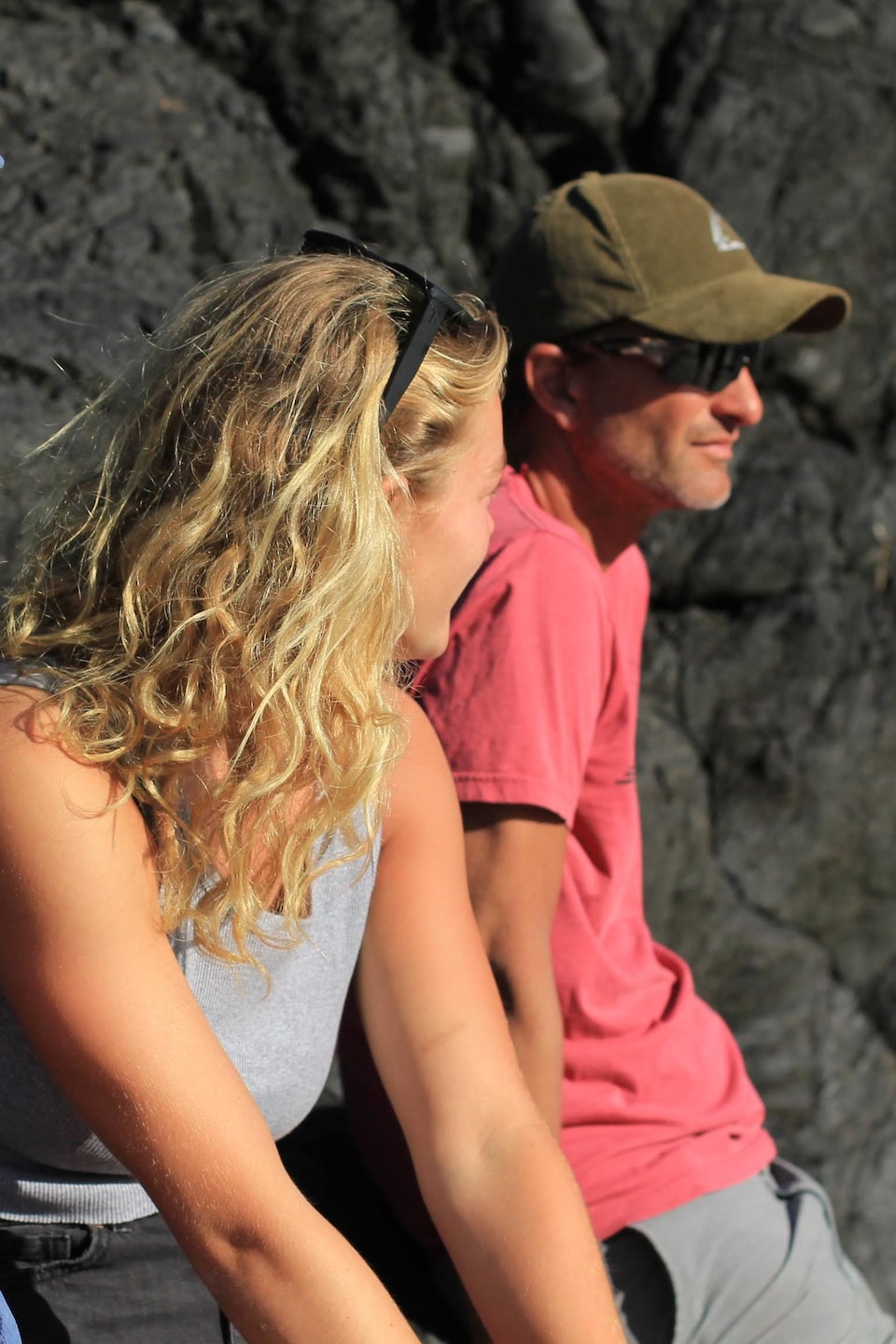 Trois membres d'une famille adossés aux rochers.