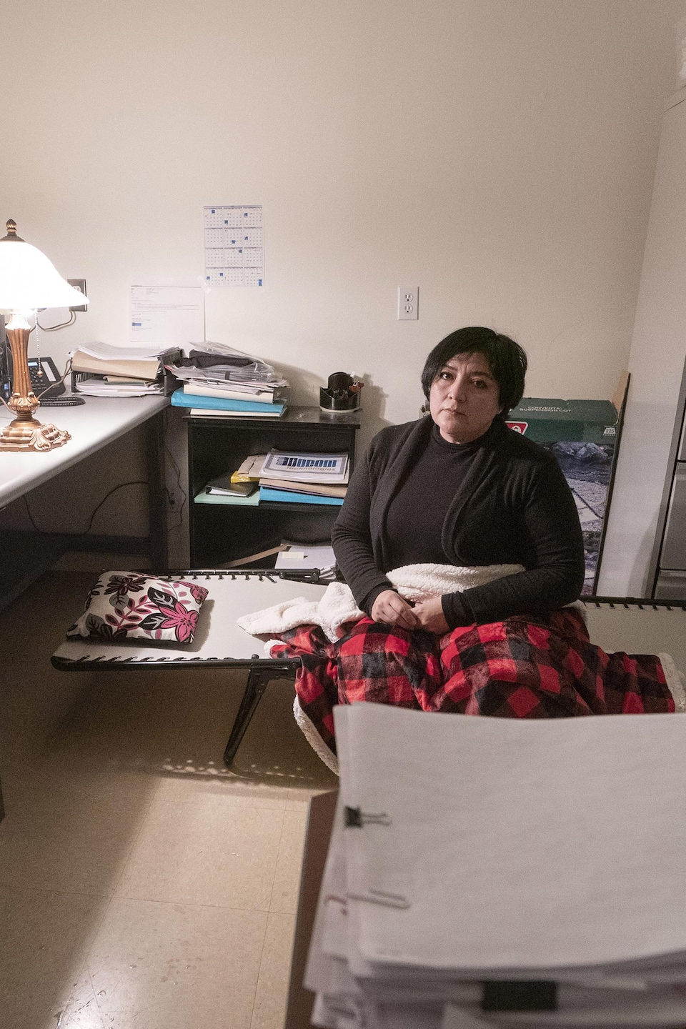 Eugenia Pineiro Cota assise sur un petit lit de camp dans son bureau de travail.