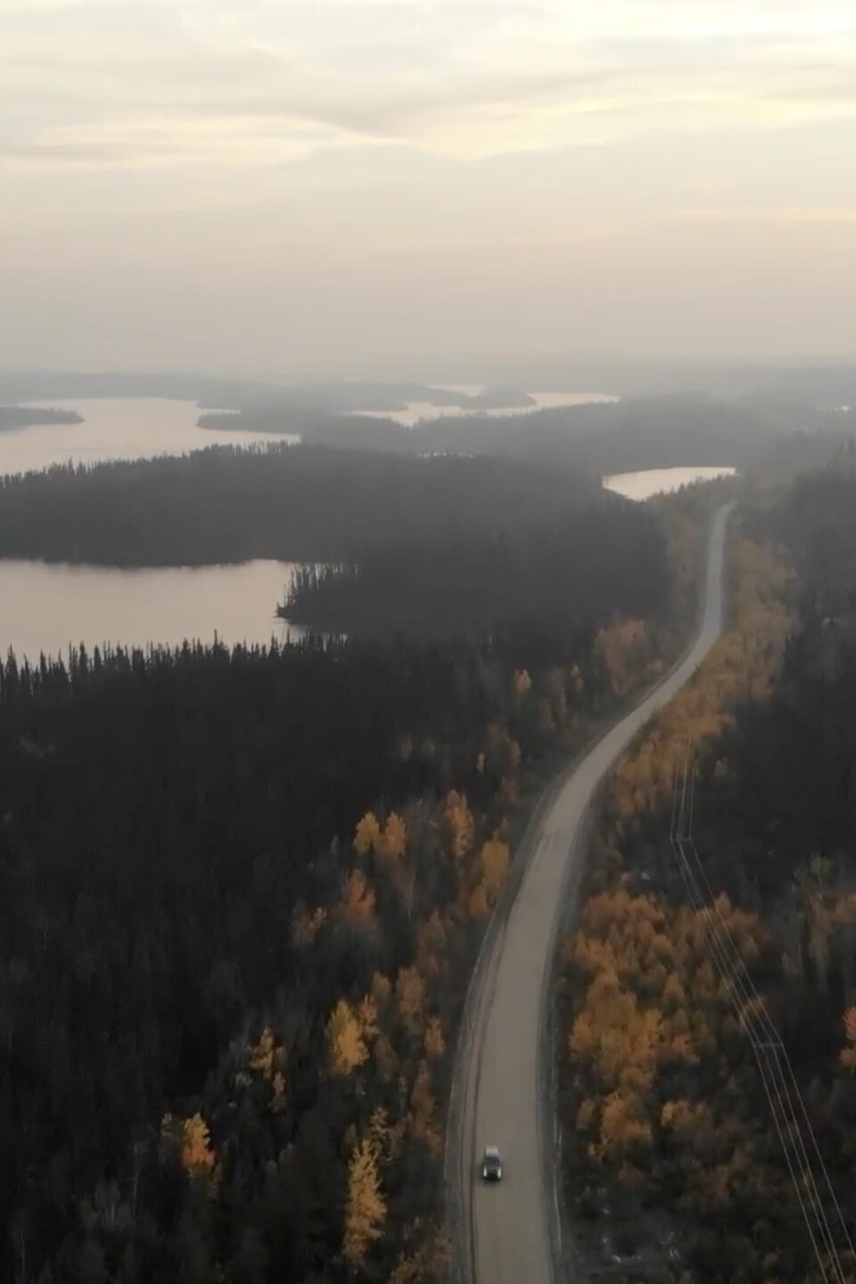 Capture d'écran d'une vidéo de drone qui survole une route sinueuse longeant plusieurs lacs