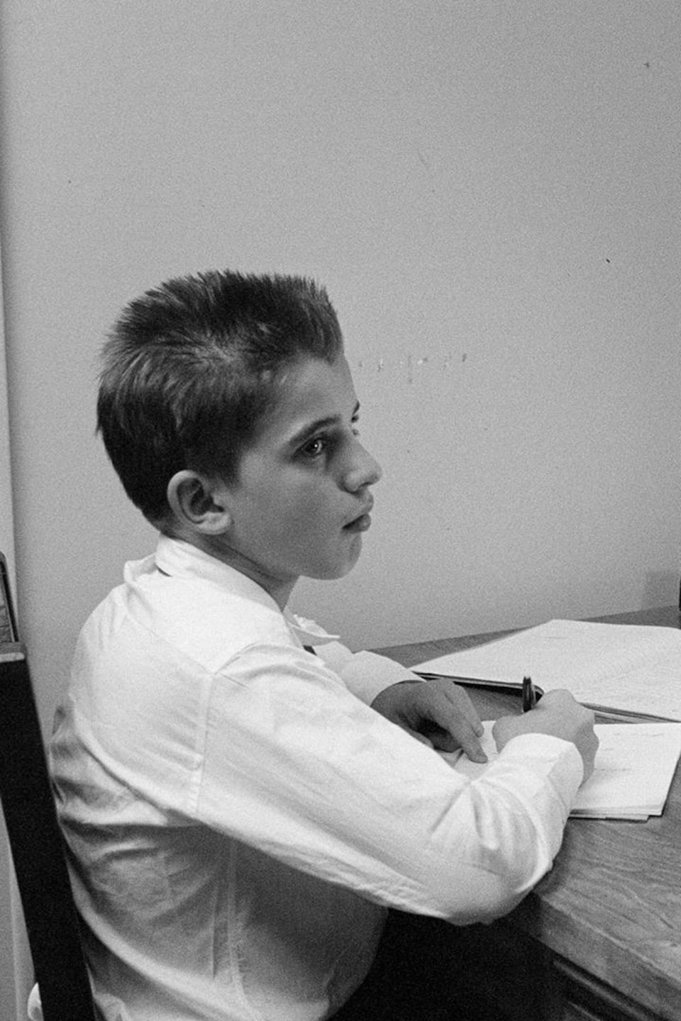 Un enfant fait ses devoirs en compagnie de son frère plus âgé.