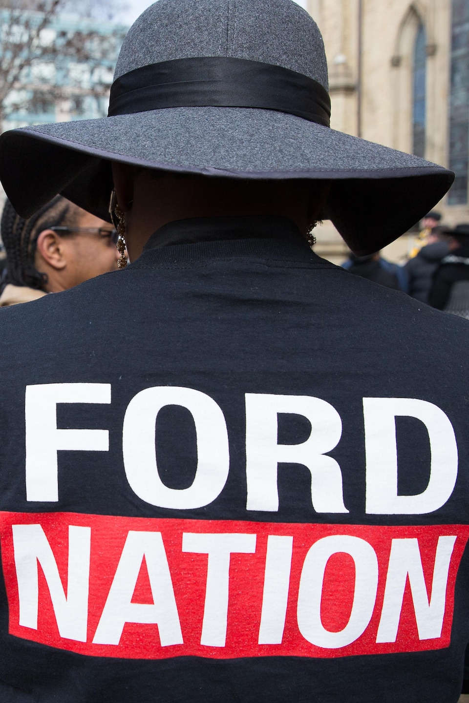 Une femme porte une chemise en denim aux funérailles de Rob Ford avec le logo de la Ford Nation sur le dos. 