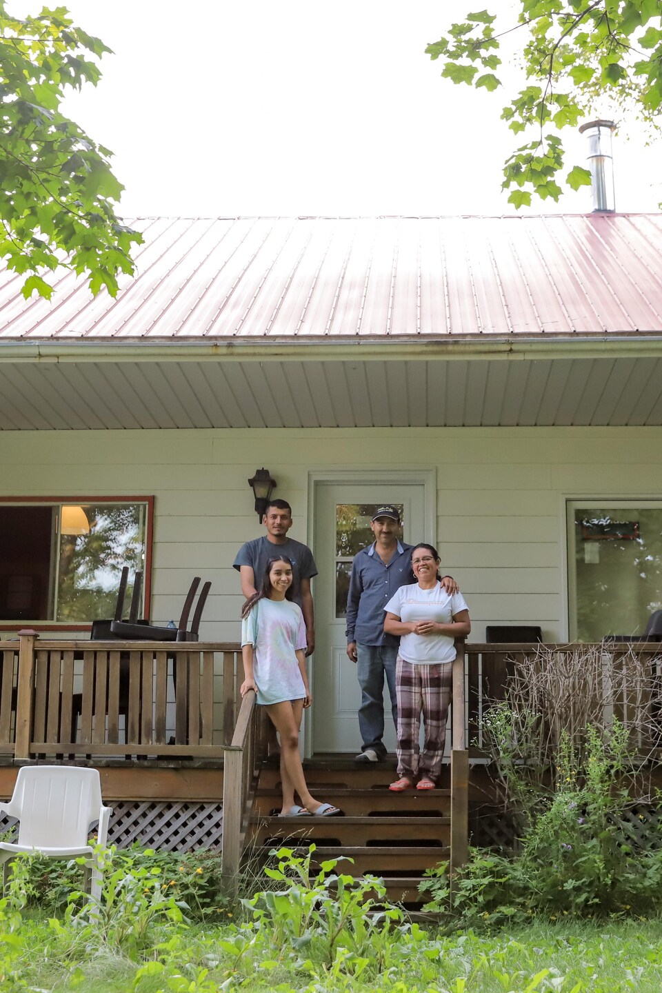 Quatre personnes debout sur le balcon d’un chalet.