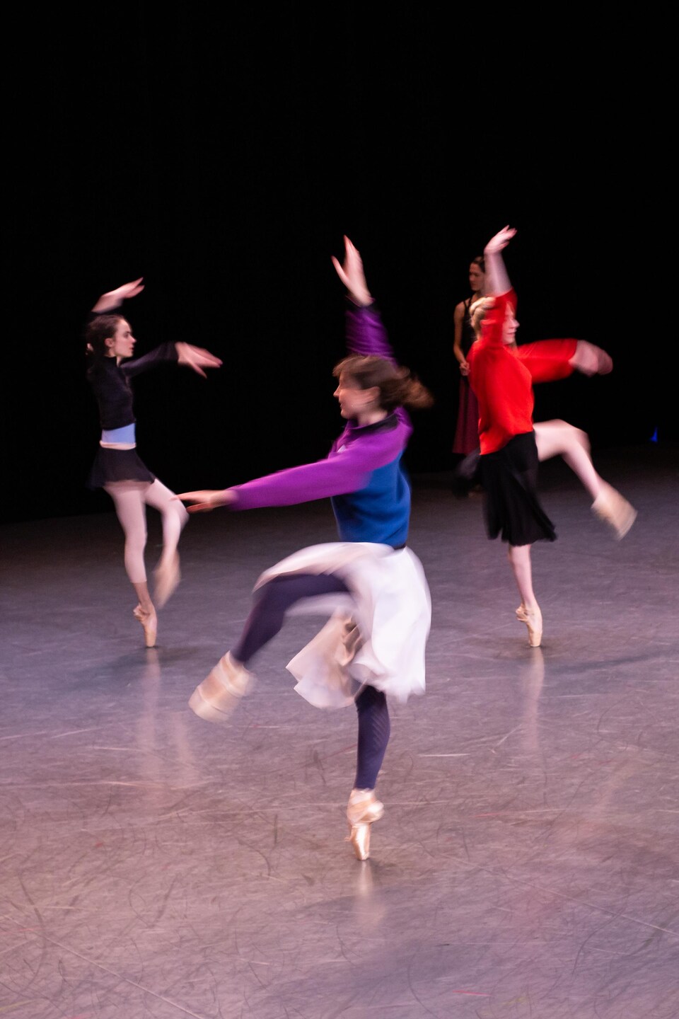 Des danseuses de ballet exécutent un pas de danse à l'unisson.