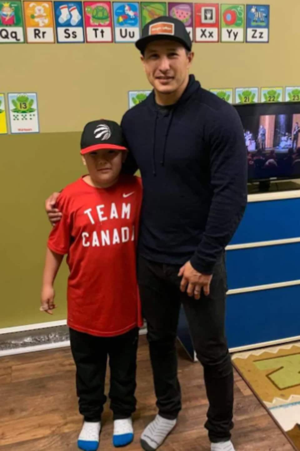 Former hockey player Jordin Tootoo poses with Washiiyeh Jeannotte for a photo