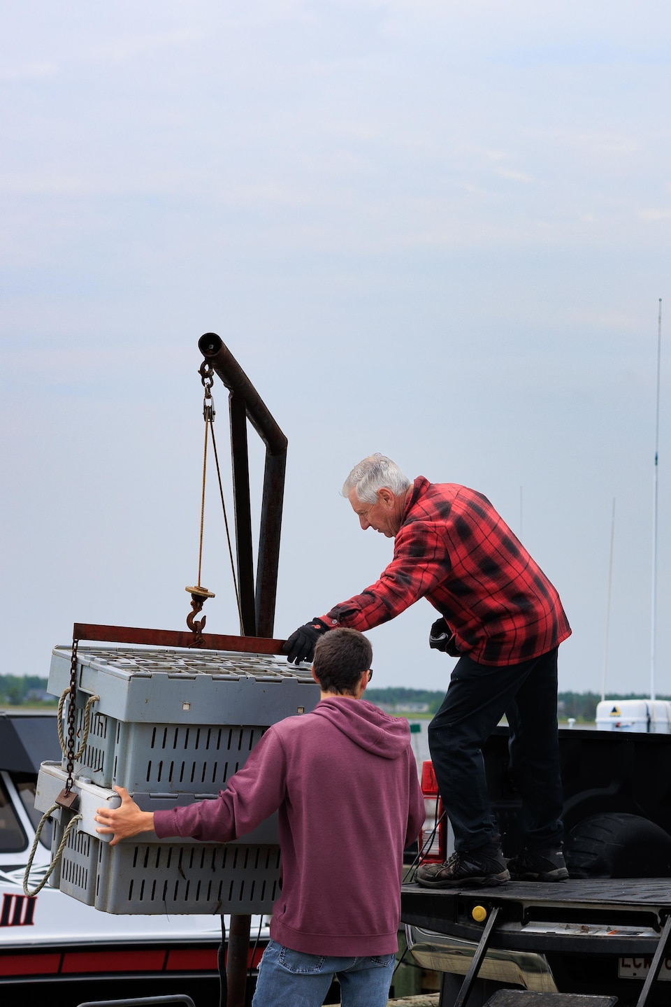 Deux hommes placent des caisses dans un camion.