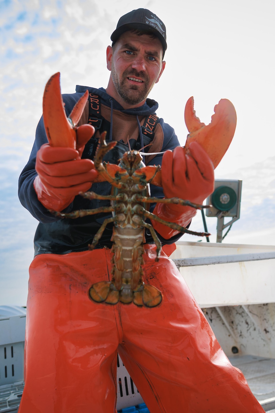 Marc-André Thériault tient un énorme homard entre ses main.