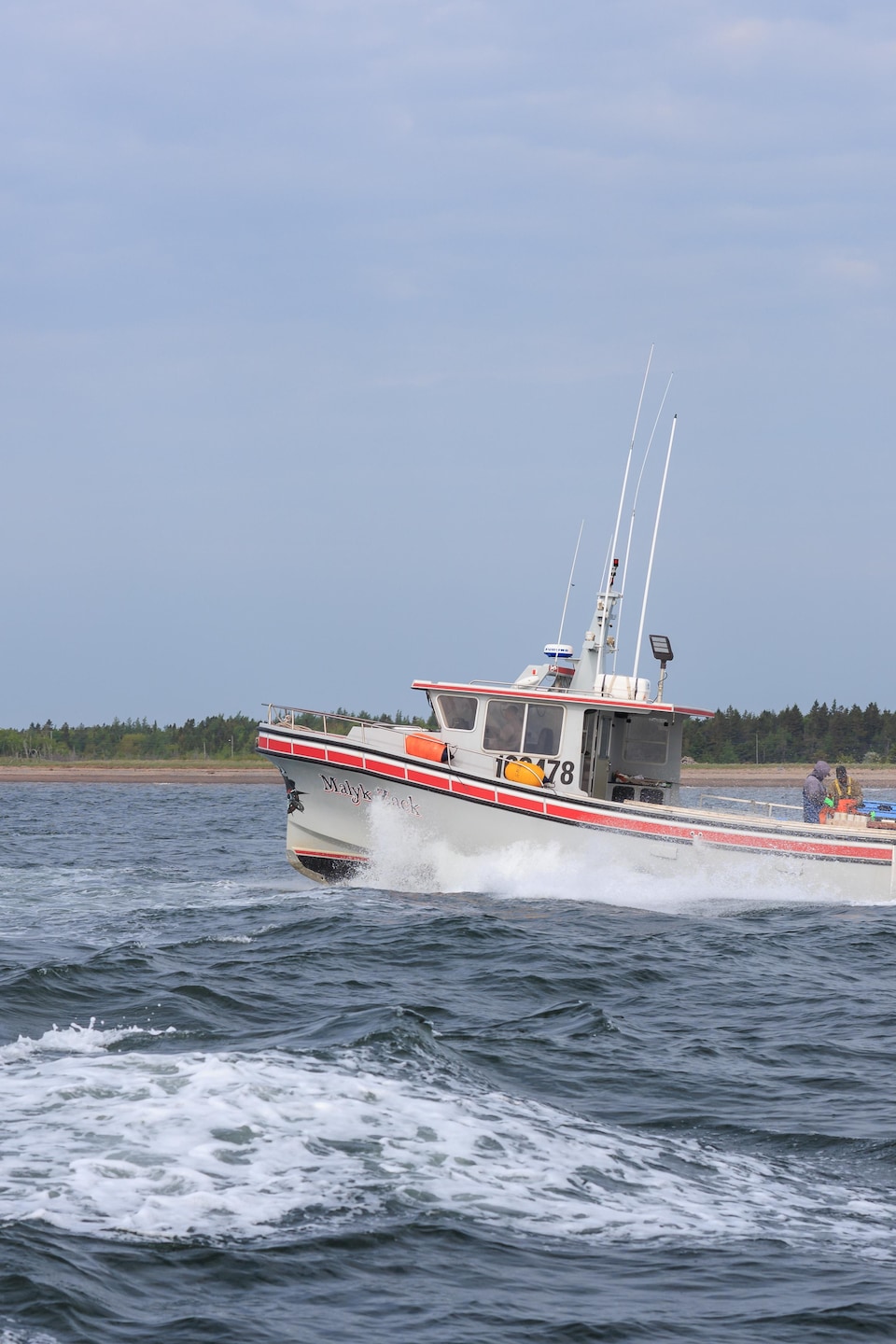 Un bateau qui accélère non loin de la côte. 