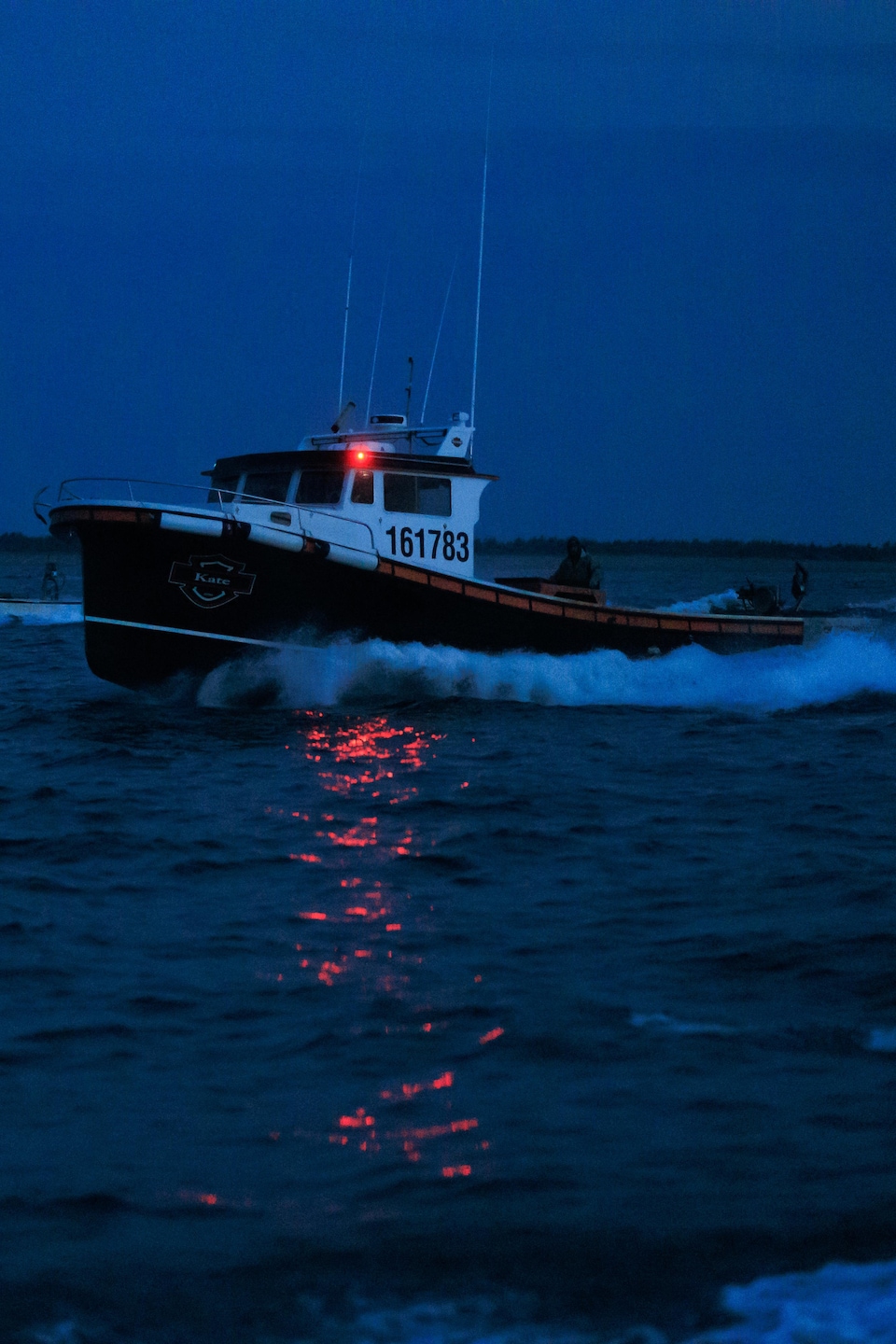Des bateaux de pêches qui fracassent les vagues en mer.