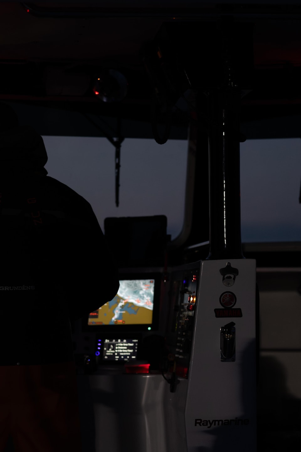 Un capitaine dans la noirceur avec plusieurs écrans qui l'illumine.