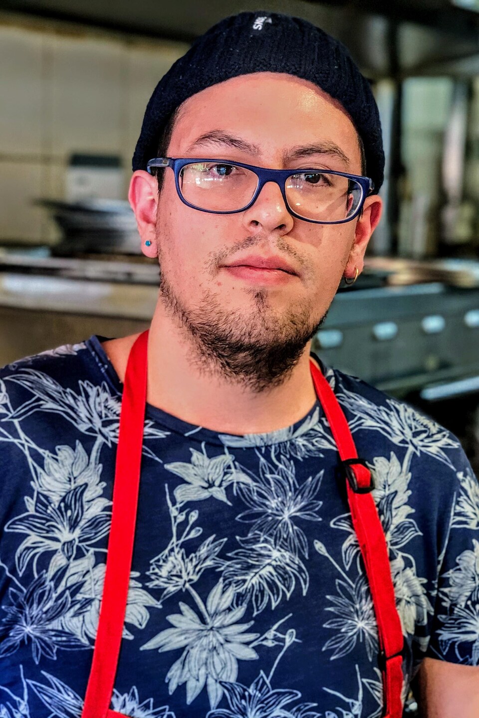 Portrait de Junior Caceres dans la cuisine de la pizzeria.