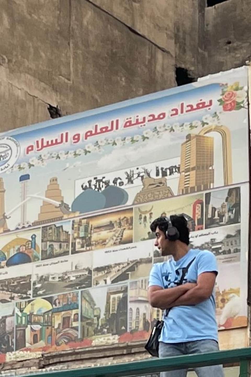 Mohammed devant une murale.