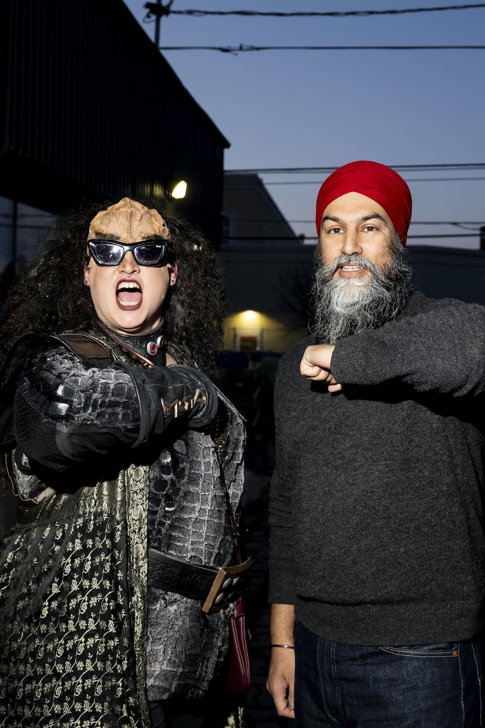 Jagmeet Singh et deux militants déguisés lèvent le coude. 