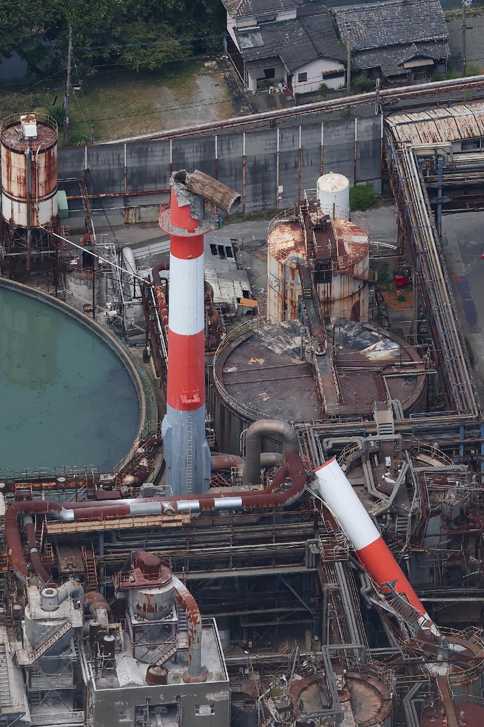 Vue aérienne d'une usine, dont une cheminée s'est effondrée.