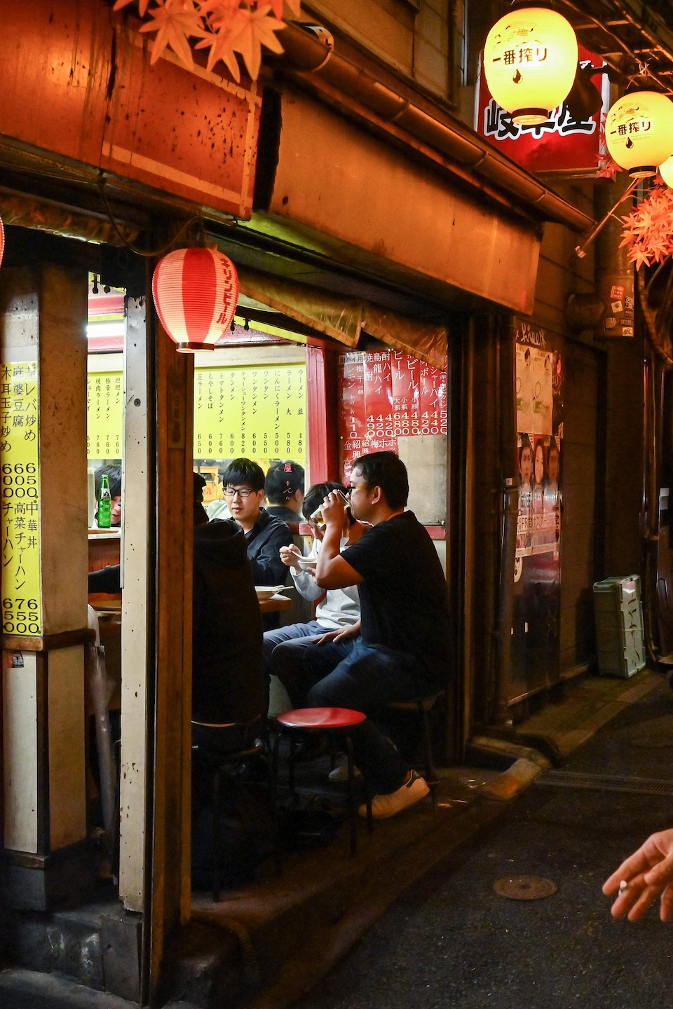Des personnes appréciant la vie nocturne de Tokyo dans des petits restaurants de rue.