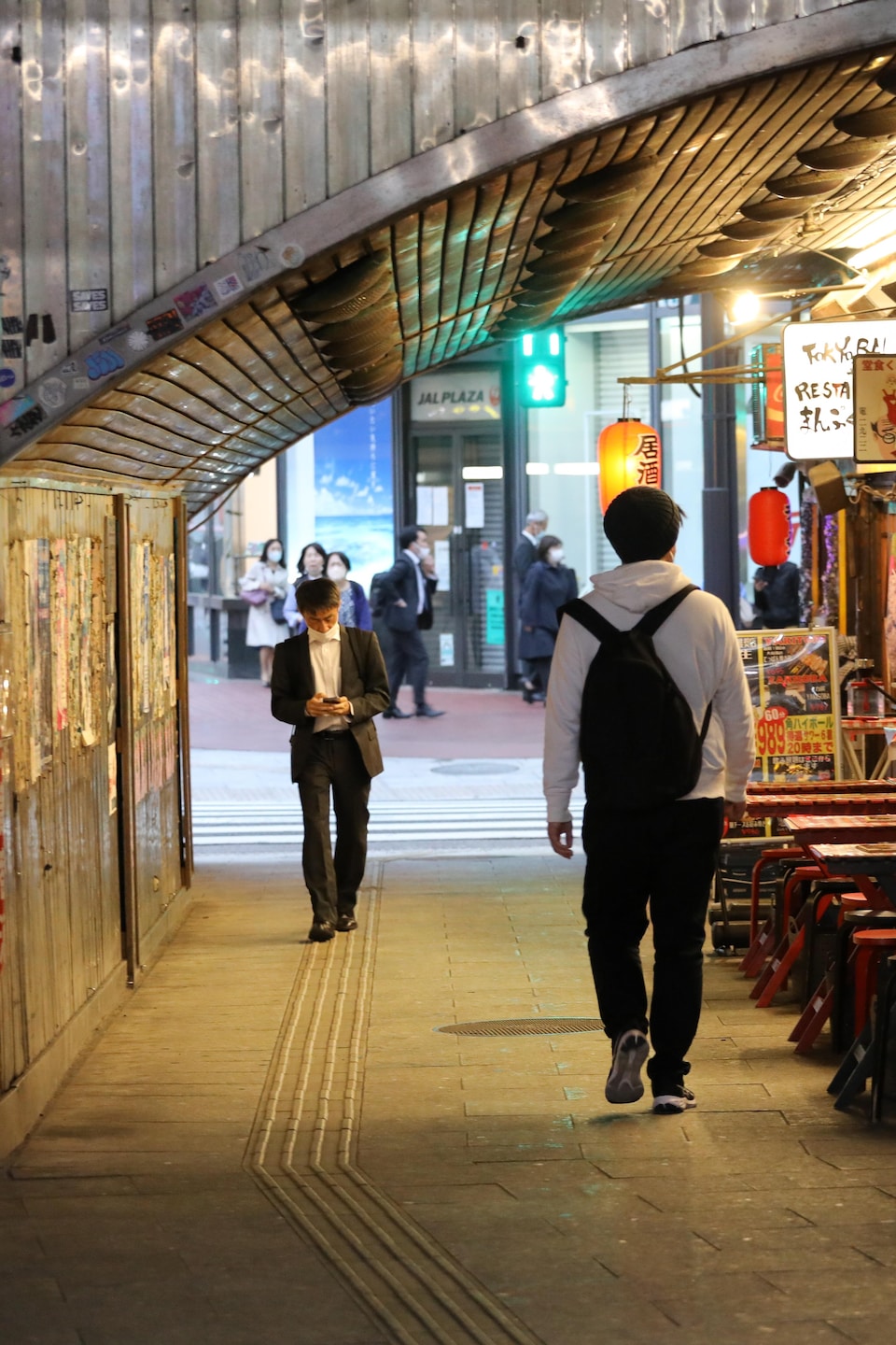 Deux hommes se croisent sans se regarder le soir à Tokyo.