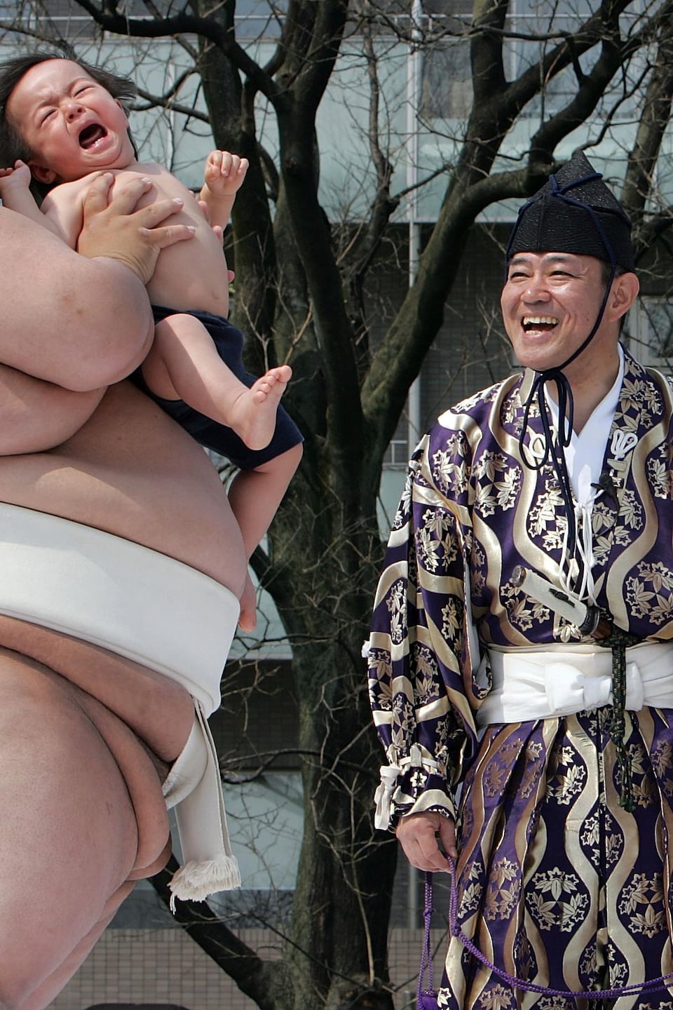 Deux lutteurs sumo tiennent des bébés.