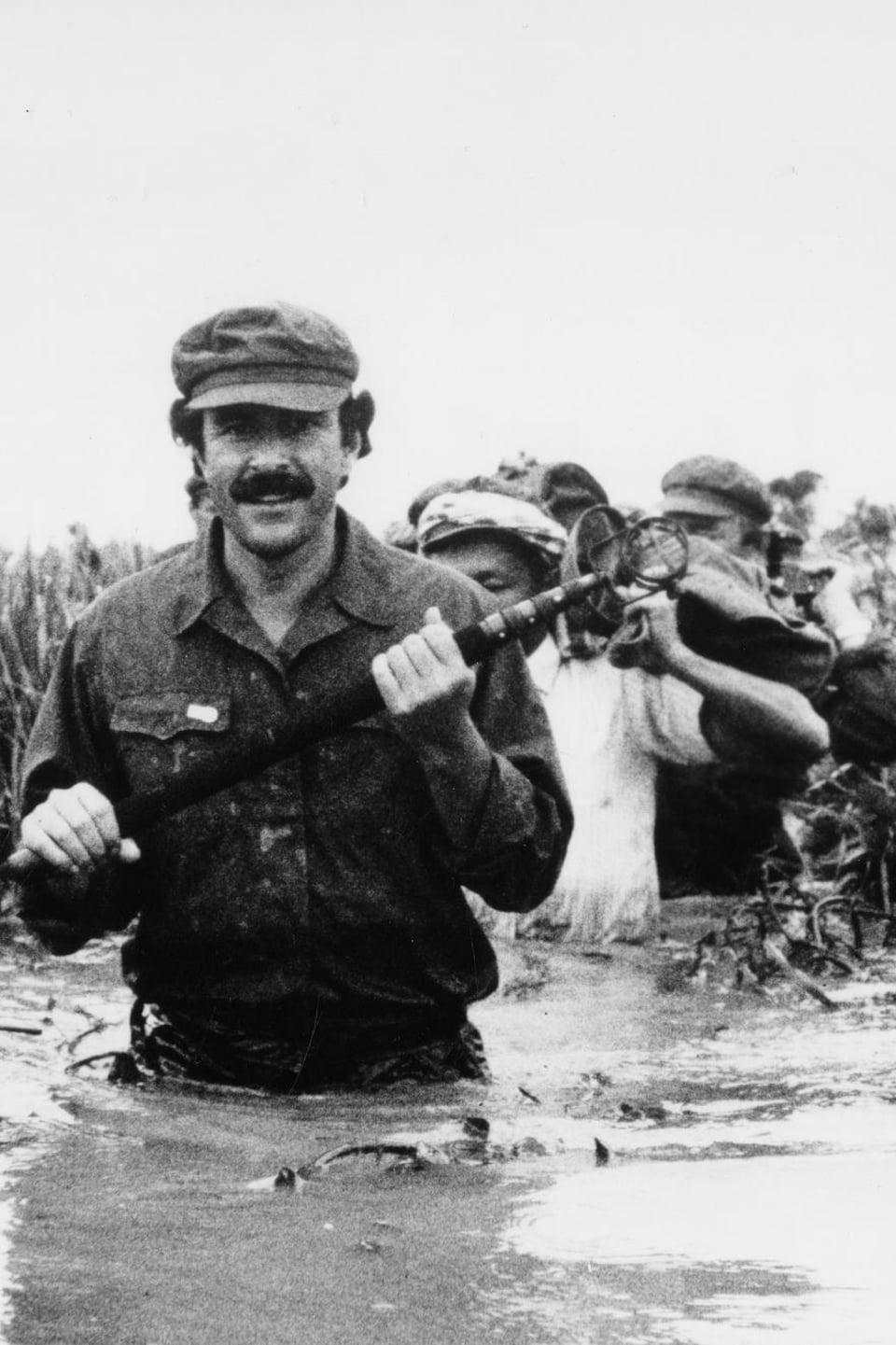 Le journaliste Jean-François Lépine marchant dans un marais, avec les guérilleros khmers rouges à l'intérieur du Cambodge, en juillet 1984.