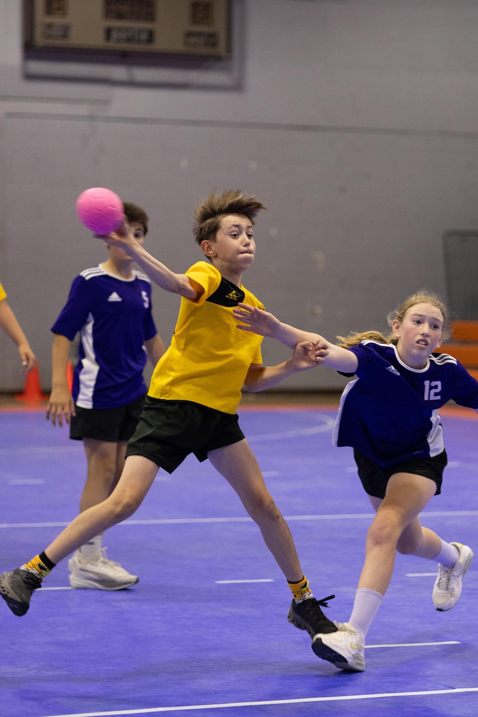 Joueurs et joueuses sur un terrain de mini handball.