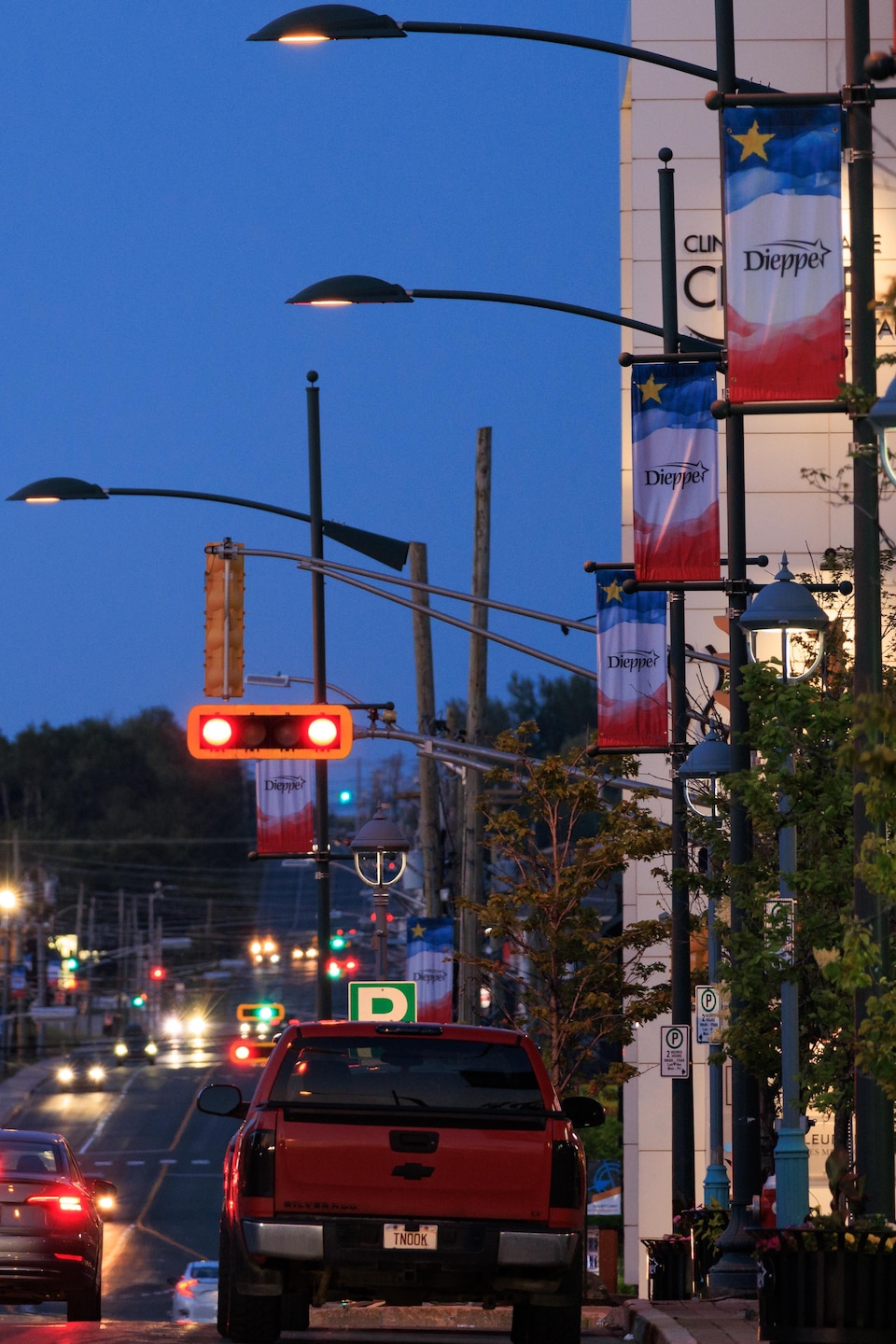 Plusieurs voitures circulent sur la rue Champlain alors que le soleil se couche.